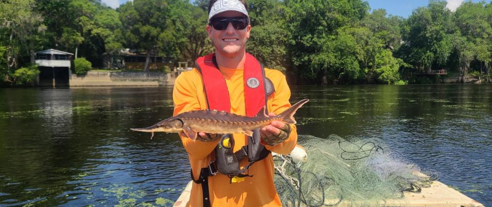 a man holds a sturgeon 
