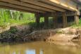 A water quality testing line is dropped into water off a bridge 