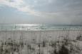 a sandy beach is shown with sea oats in the foreground