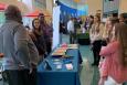 People gather around an outreach table.