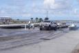 A truck pulling a boat out of the water at a new boat ramp.