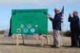 Governor John Bell Edwards in front of a project dedication sign.