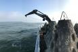 A barge and crane deploy artificial reefs along the Texas Gulf coast.