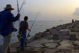 Adult and child holding fishing gear, walking on a pier in Louisiana.