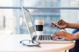 A person's hands on a laptop, with a phone in one hand. Image rotated horizontally. Credit: Women of Color in Tech. License: https://creativecommons.org/licenses/by/2.0/legalcode