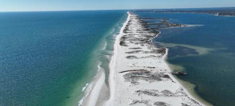 ocean is on either side of a long sand island 