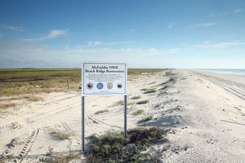 Sign with project information in front of a restored beach in Texas.