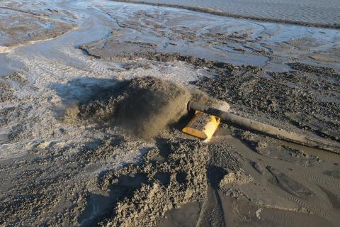 A pipe expels water and sediment at a construction site