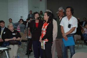 Five people stand in line to speak into a microphone