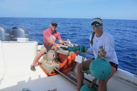 Two scientists prepare to deploy an acoustic receiver to monitor tagged fish.