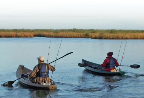 Two people fishing from kayaks